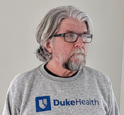 gallery position 1 showing a man with glasses wearing gray DukeHealth sweatshirt Support Greg Profits Pay for Alzheimer's Treatments