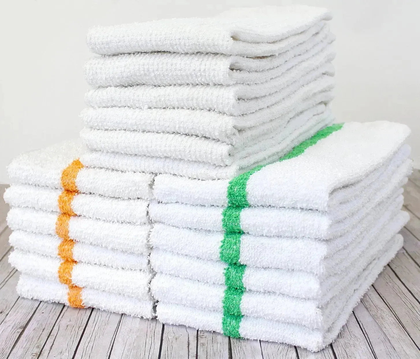 Stack of white towels with colorful stripes on a wooden floor.